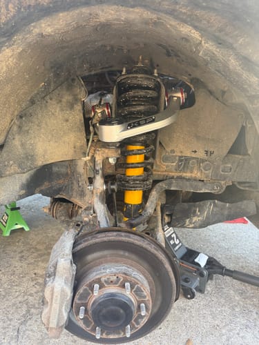 Customer's KSP Forged Aluminum Front Upper Control Arm installed on a Tacoma's front suspension system in a wheel well.