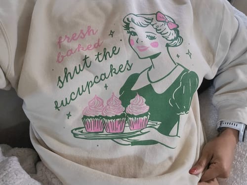A reviewer wearing the oversized Shut The Fucupcakes Sweatshirt, showing the retro graphic print.