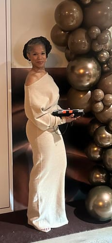 Reviewer standing in a beige Knit Off-Shoulder Sweater Maxi Dress. The long dress is shown touching the floor.