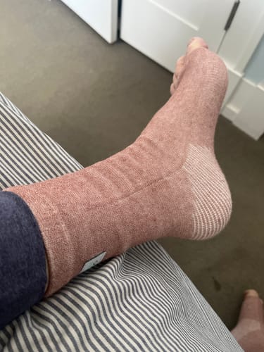 Customer wearing the pink Anti-Fatigue Bamboo Footsleeve, showing the textured compression design on their foot.