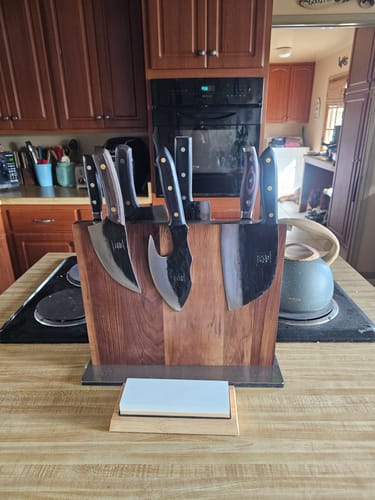 Customer's Walnut Magnetic Knives Holder on a kitchen countertop, holding several large knives.