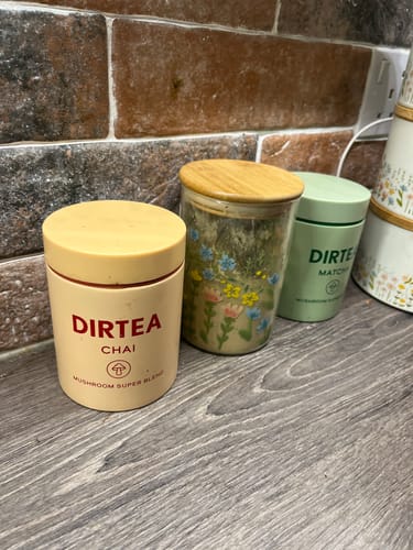 Customer's DIRTEA Chai canister on a kitchen counter next to other tea containers.