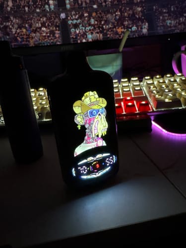 Kundenfoto des Fumot RandM Digital Monkey. Das Gerät steht auf einem Schreibtisch und sein buntes Smart Display leuchtet.