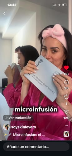 Reviewer in a pink robe holding the packaging for The Micro Infusion System.