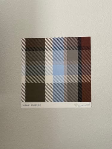 Customer's sample of the plaid Samuel Wallpaper adhering to a textured wall.