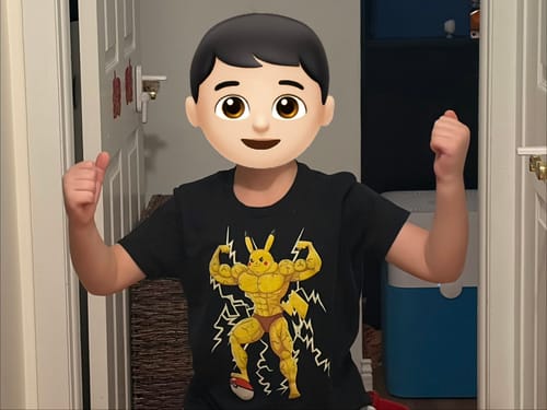 Customer's son wearing the black Pumpachu Kids T-Shirt and flexing his arms in a hallway.