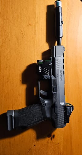 Customer's Site Right 2.0 Boresighter in the barrel of a pistol with an optic and laser sight attached.