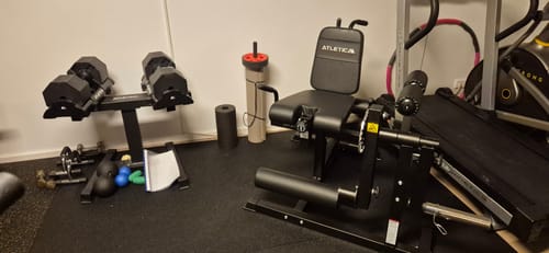 Ein Kunde zeigt seinen schwarzen Fullbody Multitrainer in einem Heimstudio.