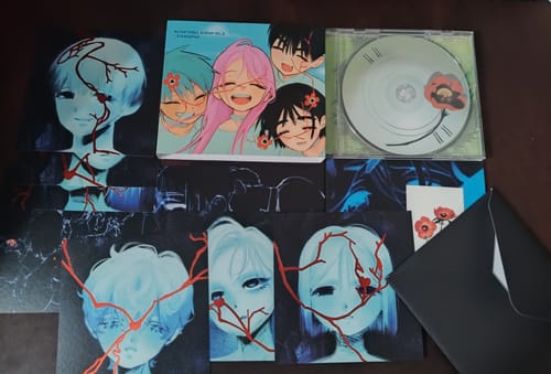 Customer's Alien Stage - Album displayed with its CD, a colorful booklet, and several character art cards.