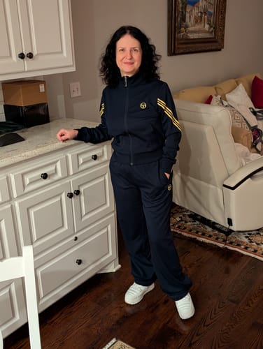 Customer standing indoors wearing the Sole Track Jacket and matching pants in Maritime Blue, showing the fit.