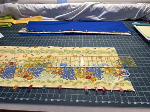 Customer's large Dual Sided Cutting Mat on a table, holding fabric and a ruler for a quilting project.