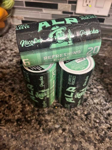 Customer's three sleeves of Refreshing Chill Nicotine Pouches stacked in a pyramid on a dark countertop.