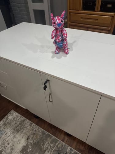 Customer's white Sydney XL Sewing Cabinet in its compact, closed state with a plush toy on top.