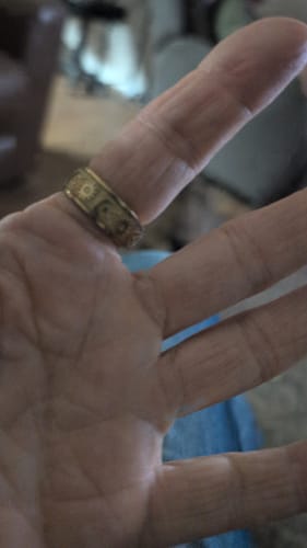 Close-up of reviewer's hand wearing the detailed, gold Celestial Ring.