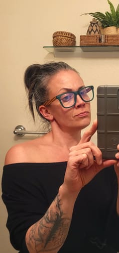 Reviewer takes a selfie wearing the square, green-framed Seaglass Blue Light Readers.
