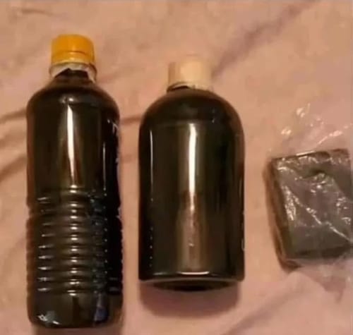 Customer's blurry image of two bottles containing a dark liquid and a wrapped solid item.