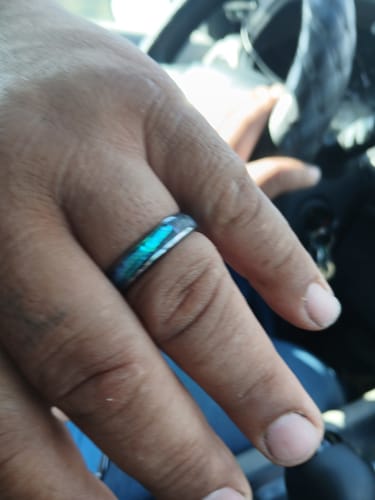 Customer wearing the Nerium ring, highlighting the iridescent blue and green abalone inlay.