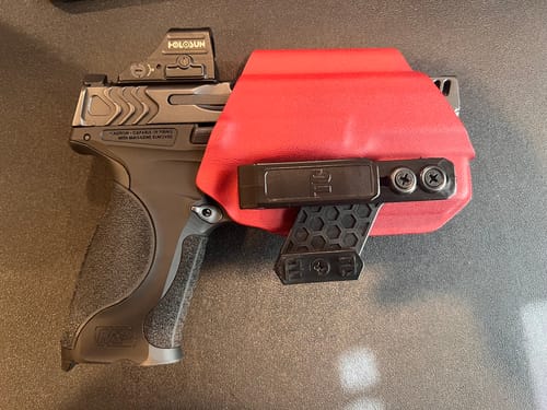 Customer's red T1-M holster holding a pistol with an optic, showing the single-clip design for concealed carry.