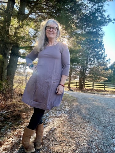 Reviewer showing the fit of the Rissa A Line Dress in Toasted Almond, worn over leggings outdoors.