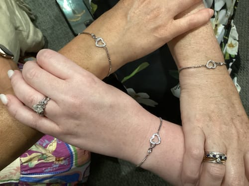 Customer photo showing three people's wrists, each wearing the 'To My Daughter - Forever Love Bracelet'.