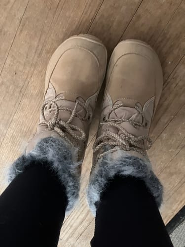 Customer wearing tan boots with grey fuzzy trim, seen from a top-down perspective.