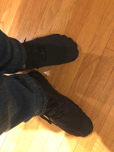 Customer wearing black Will II - Winter Barefoot Shoes, viewed from above on a wooden floor.