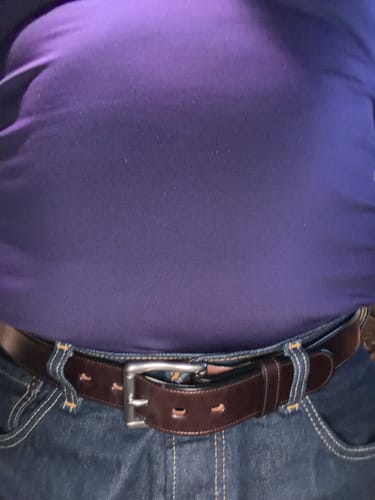 Customer wearing the brown leather Canyon belt with a silver buckle and blue jeans.