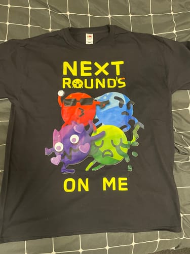 Reviewer's black Summer t-shirt with a colorful 'Next Round's On Me' graphic laid flat.