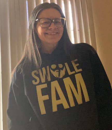 Reviewer smiling while wearing the black SwoleFam Hoodie with yellow text.