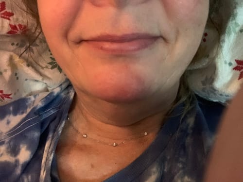 Close-up of a reviewer's lips showing the subtle color from one swipe of plum lip balm.