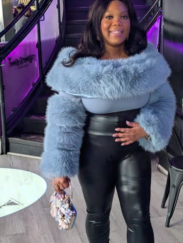 Reviewer smiling in a soft, light blue Faux Fur Off-Shoulder Pelted Top at an indoor event.