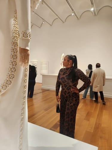 Reviewer posing in the leopard print Naked Print Wide-Leg Jumpsuit at an art gallery.