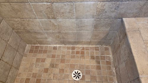 Customer's tiled shower before using Bathroom Concentrate, showing stained tiles and dirty grout.