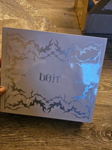 Customer holding the sealed STRAY KIDS - DO IT TAPE ALBUM box with its shiny, silver-foil design.