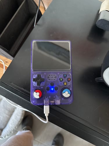 Customer's transparent purple RetroGame Pro charging on a desk, with custom Poké Ball analog stick caps.
