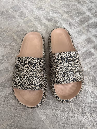 Customer's pair of leopard-print slides with thick soles shown on a carpet.