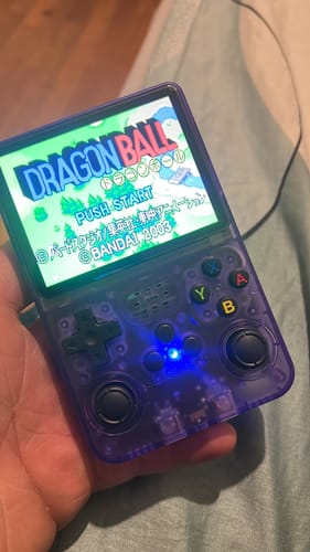 Customer holding the purple translucent RetroGame Pro with the Dragon Ball game loaded on the screen.