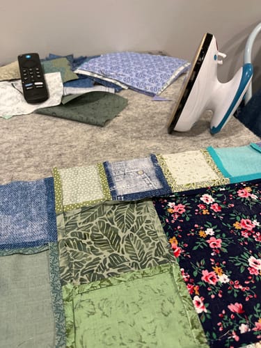 Customer's Sew Creative Wool Pressing Mat with a small iron and colorful quilt blocks during a sewing project.