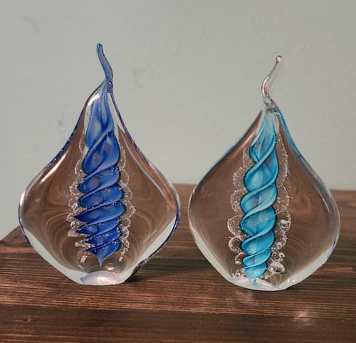 Reviewer's two Memorial Glass Flames with ashes, one with a dark blue spiral and the other with a light blue spiral.