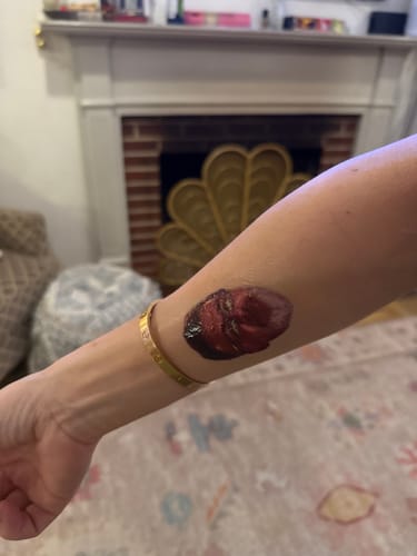 A reviewer's forearm displaying a newly applied Custom Photo Face Temporary Tattoo.