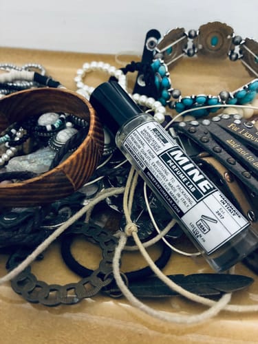 Il profumo OUD del recensore, adagiato su un vassoio tra gioielli in stile country.