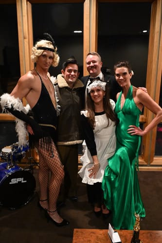 A group of customers in fun 1920s-themed costumes for the Murder Mystery Game Kit party.