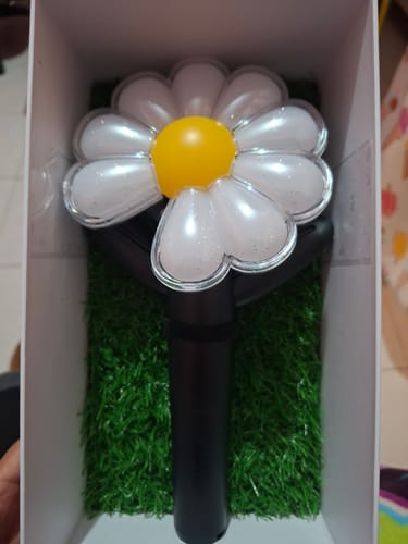 Customer's G-DRAGON official light stick, shaped like a shimmery daisy, displayed in its open box.