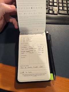 Customer holding their Track Pad Pro open, showing handwritten entries and the attached pen.