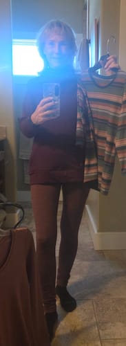 Reviewer in a mirror selfie wearing the Grape Harvest Frost Duralite® Leggings, holding up tops to show color coordination.
