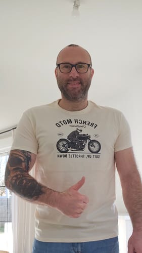 Client portant le T-shirt blanc naturel de la COLLECTION GENTLEMEN avec un motif de moto, levant le pouce.