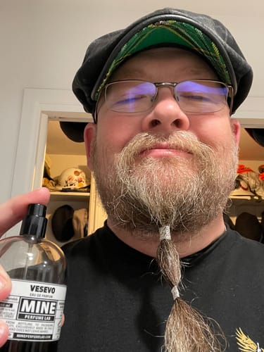 Un cliente mostra la sua boccetta di profumo VESEVO in una foto selfie.