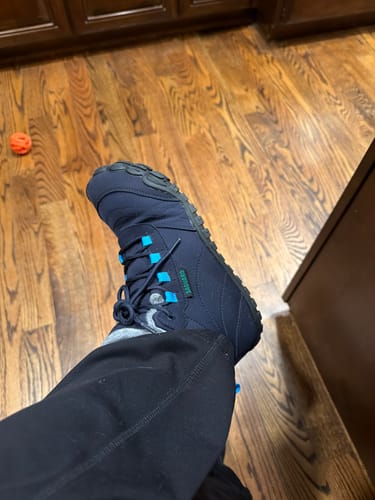 A customer's view of their foot inside a navy Will II Winter Barefoot Shoe with blue accents.