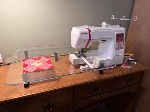 Reviewer's clear Sew Steady Sewing Machine Extension Table fitted perfectly around a sewing machine on a wooden desk.