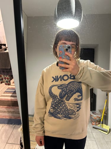 Customer wearing the beige Late Cretaceous Bonk Crewneck, showing the fit and graphic in a mirror selfie.